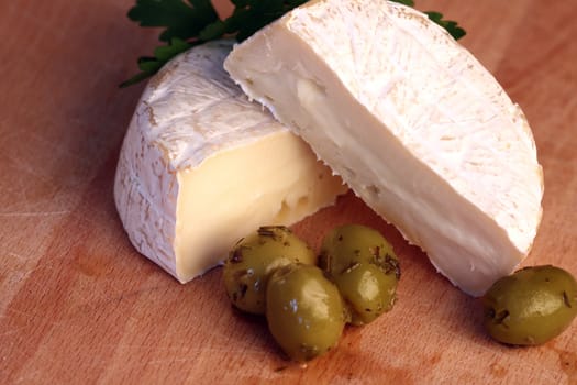 Close up of camembert cheese and olives with spices