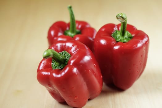Three red peppers on a kitchen table