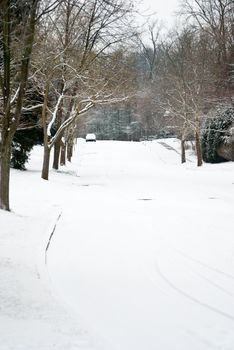 A neighborhood street is covered with fresh snow.