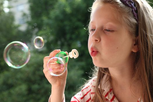 An image of a nice little girl making bubbles