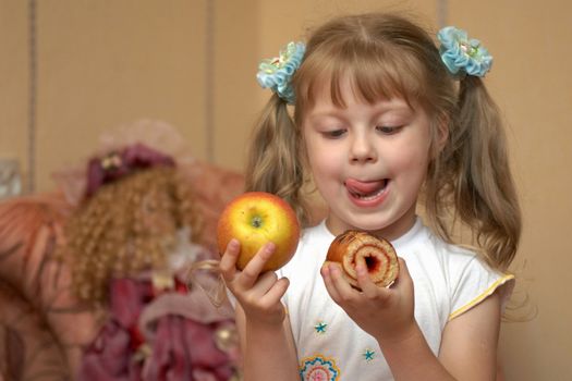 A girl holding an apple and a cake