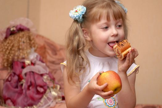 A girl holding an apple and a cake