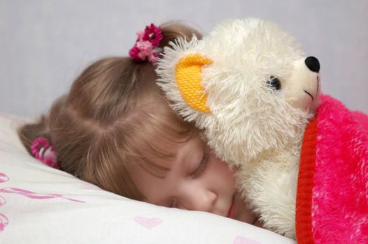 A little girl sleeping with a toy