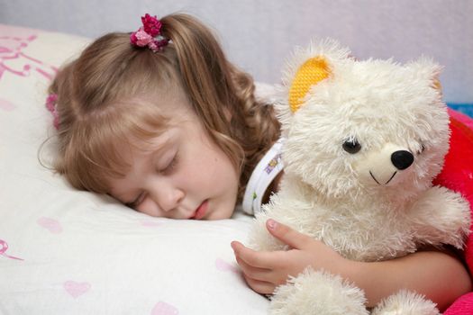 A little girl sleeping with a toy