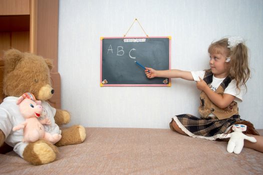 An image of girl with toys and school alackboard