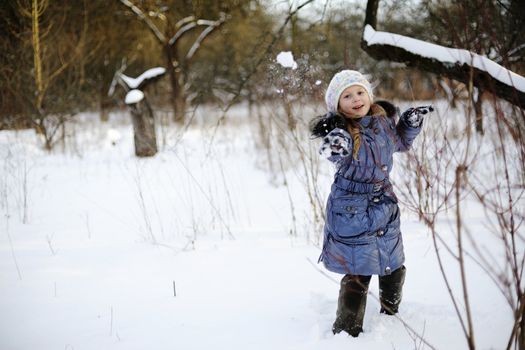 An image of a little girl playing snowballs