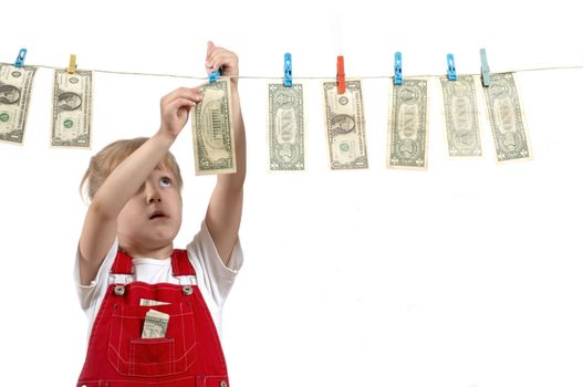 A girl in red overalls hanging up dollars