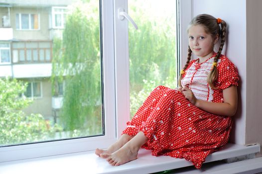 An image of a nicel little girl on the window