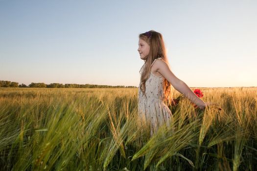 An image of a girl in the field of barley at sunset