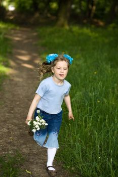 Nice girl running on a lane in the summer park