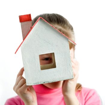 An image of a child looking into the window of little house