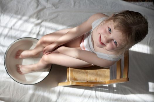 A nice girl washing her feet in a wash-basin