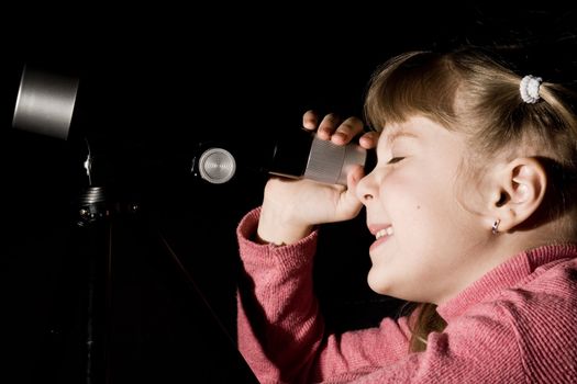 An image of a girl looking into a telescope