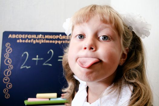 Fun. An image of Little girl sitting near chalkboard. 