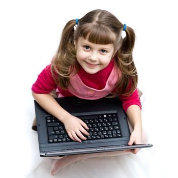 An image of a little girl with laptop sitting on the floor