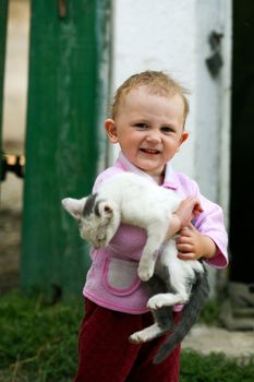 The happy child with a cat in her arms