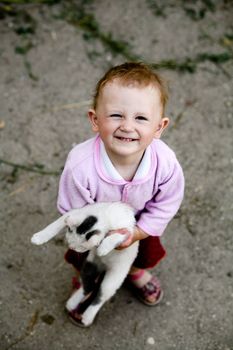 The happy baby-girl with a cat in her arms