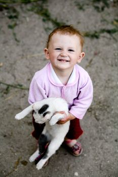 The happy child with a cat in her arms