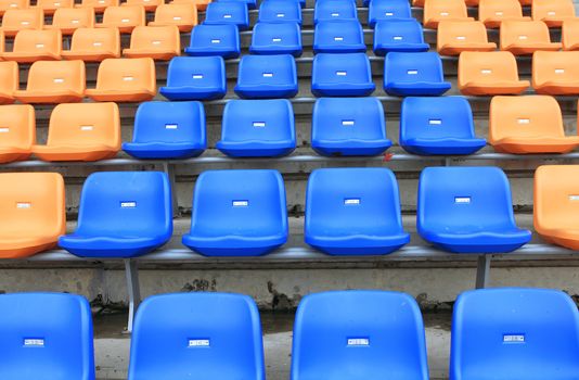 plastic, yellow and blue, new chairs in stadium.