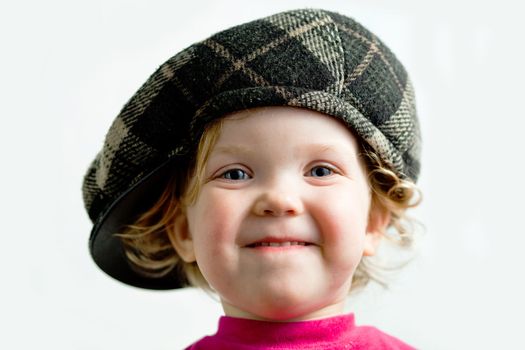Stock photo: an image of a playful girl in brown cap
