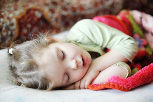 An image of a little girl sleeping on a bad