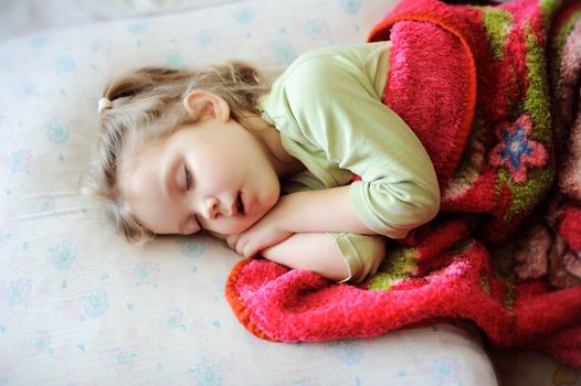An image of a little girl sleeping on a bad