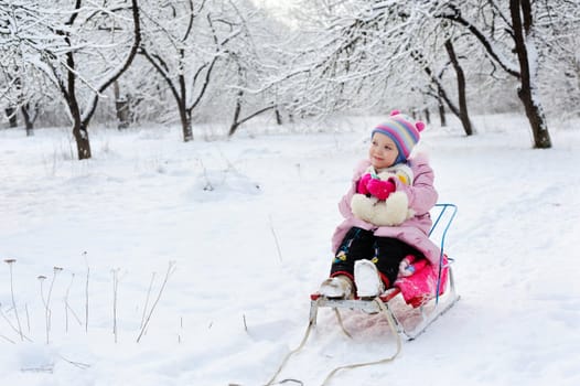 An image of a child sitting on sledge