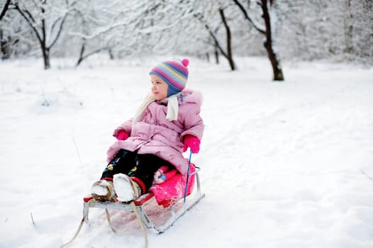 An image of a child sitting on sledge