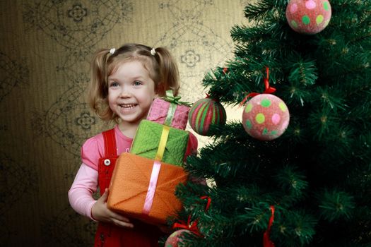 A little girl with three boxes with presents