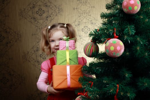 A little child with three boxes with presents