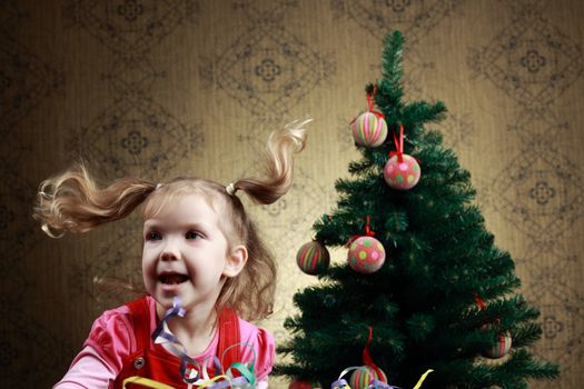 A nice girl jumping at a new year tree 