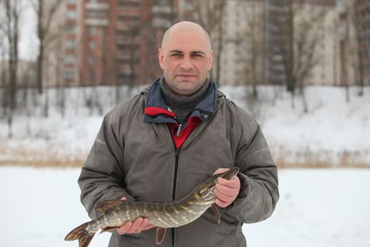 Fisherman caught a pike in the winter fishing