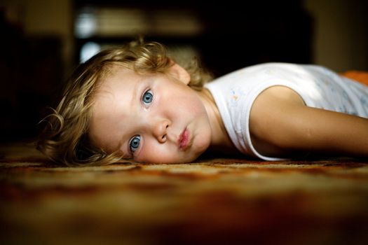 An image of little girl lying on the floor