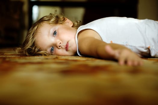 An image of  little girl lying on the floor