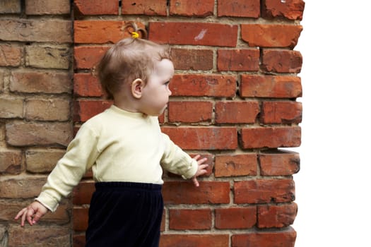 An image of baby-girl near a orange wall
