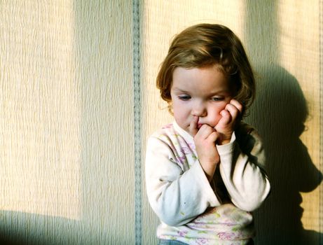 An image of a thoughtful beautiful little girl