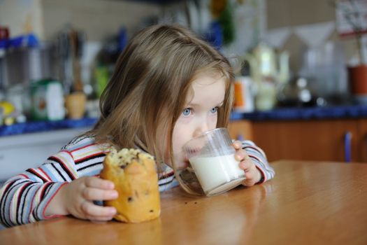 An image of a girl eating cookie with milk