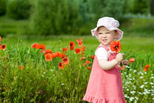 An image of baby-girl amongst field with red flowers