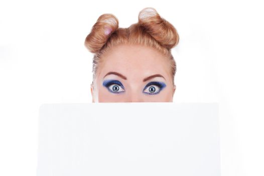 Surprised funny woman peeking over edge of blank empty paper isolated on white