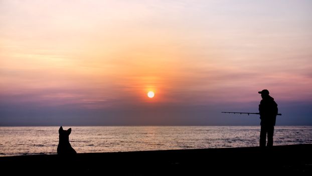Silhouette of the fishing and dog by the sea in the morning
