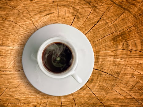 White ceramic cup of hot coffee on old wood table