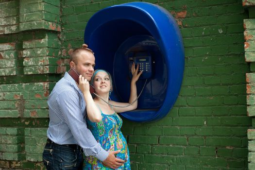 An image of a young couple at telephone in the street