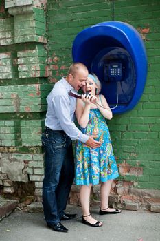 An image of a young couple at telephone in the street