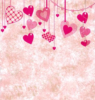 different pink hanging hearts on the grunge light paper background