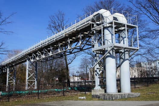 Industrial pipelines on pipe-bridge against blue sky