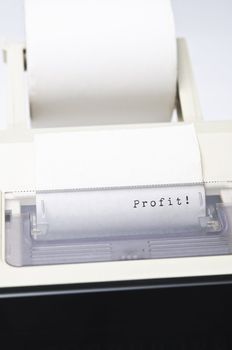 Close up of a calculator ink roll, printing the word Profit.