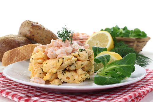 Scrambled eggs with shrimp, dill and corn salad on a plate