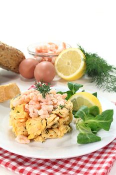 Scrambled eggs with shrimp, dill and corn salad on a plate