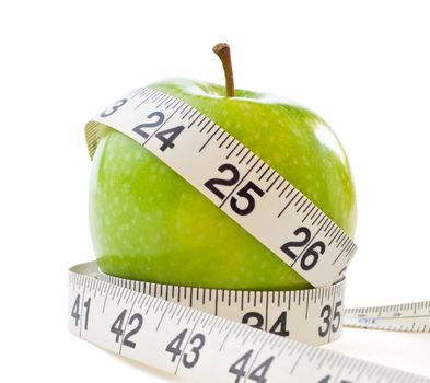 A green shiny apple, wrapped with a white measuring tape to signify dieting and weight loss.  Isolated on white background with light shadows retained.