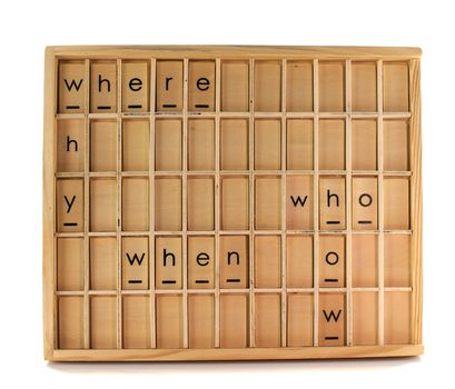 wooden education board with where when why how and who